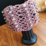Bracciale a fascia realizzato ad uncinetto nei toni del rosa antico