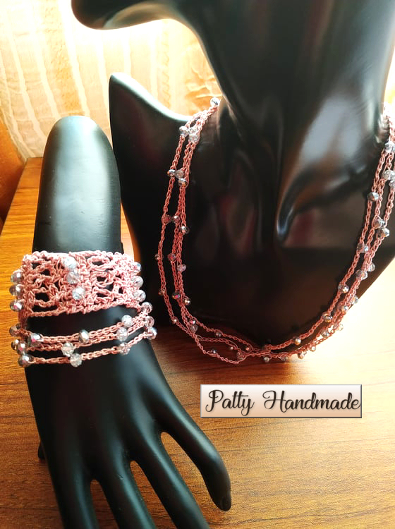 Set di collana e due bracciali realizzati ad uncinetto con filato gioiello sui toni del rosa
