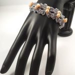 Bracciale realizzato ad uncinetto con filato gioiello color argento e mezzi cristalli sul rosa