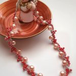 Collana relizzata ad uncinetto con perle rosate e mezzi cristalli rossi