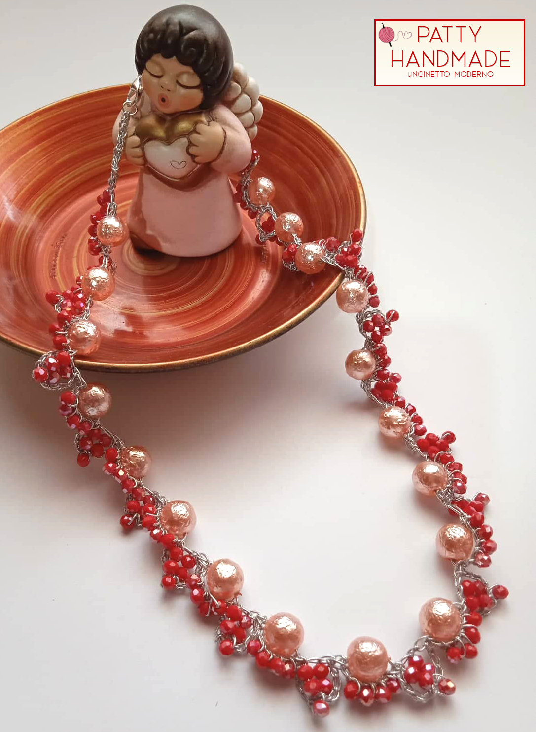 Collana relizzata ad uncinetto con perle rosate e mezzi cristalli rossi