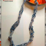 Collana realizzata ad uncinetto con filato gioiello color argento e cristallini sui toni dell'azzurro