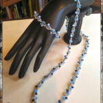 Set di collana e bracciale realizzati ad uncinetto con filato gioiello color argento e cristallini sulle sfumature dell'azzurro e del blu.