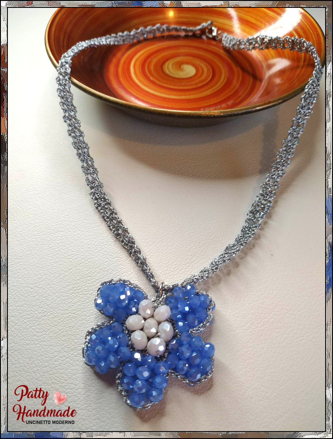 Collana con ciondolo realizzata ad uncinetto con filato gioiello di colore argento e mezzi cristalli azzurri