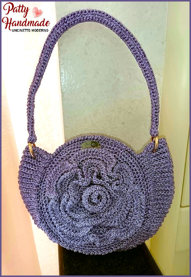 Round Bag con fiore realizzata interamente a mano ad uncinetto in filato lilla con glitter